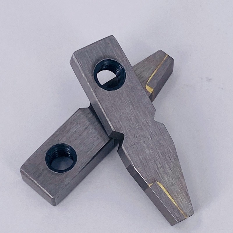 Detailed view of metal parts with precise holes and textured surfaces, showcasing manufacturing accuracy.
