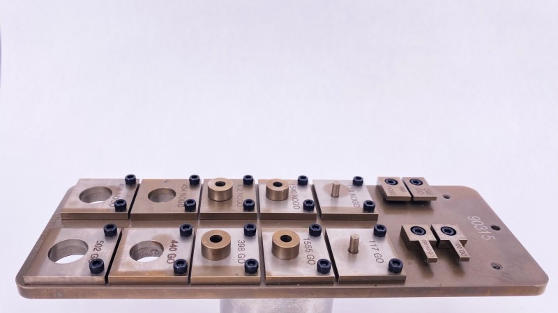 Un montaje de ingeniería de precisión que muestra varios componentes metálicos y herramientas de inspección.